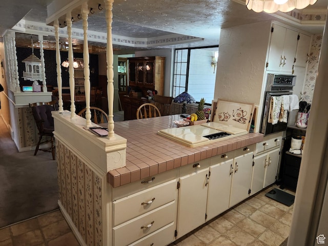 8857 S Capella Way E, Sandy, UT 84093 - kitchen featuring black oven, cooktop, a peninsula, and tile counters