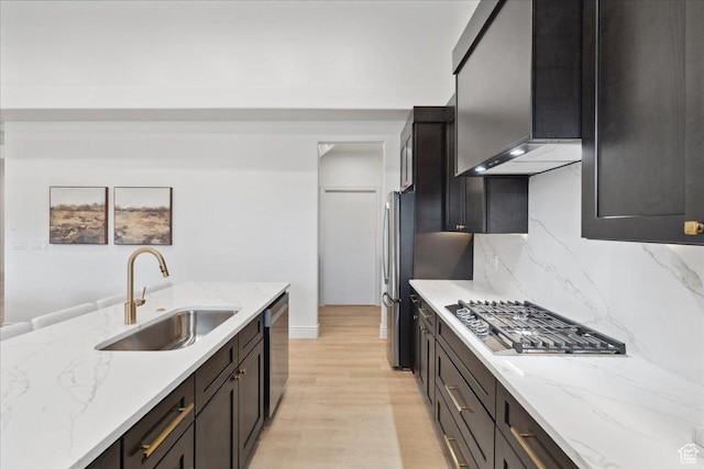 12469 S Patriot Hill Way, Herriman, UT 84096 - kitchen with appliances with stainless steel finishes, light wood-style floors, decorative backsplash, and light stone counters
