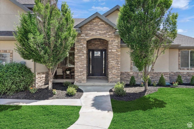 12469 S Patriot Hill Way, Herriman, UT 84096 - view of front facade with stucco siding, stone siding, a front yard, and a porch