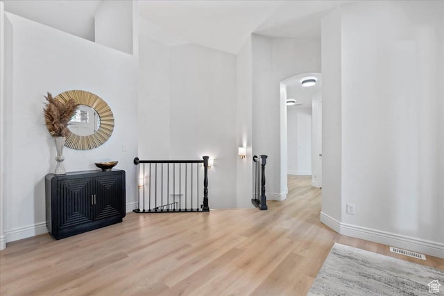 12469 S Patriot Hill Way, Herriman, UT 84096 - corridor featuring an upstairs landing, arched walkways, wood finished floors, and lofted ceiling