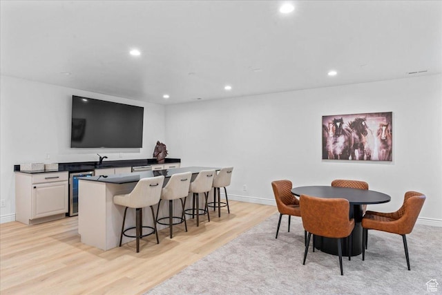 12469 S Patriot Hill Way, Herriman, UT 84096 - dining space with wine cooler, light wood-style floors, recessed lighting, and bar