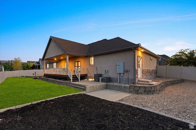 12469 S Patriot Hill Way, Herriman, UT 84096 - back of house featuring a fenced backyard, stucco siding, stone siding, a wooden deck, and a patio area