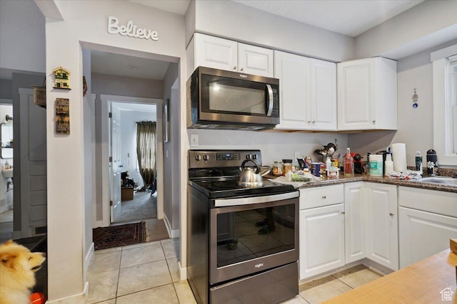 344 E Utopia Ave, South Salt Lake, UT 84115 - kitchen featuring appliances with stainless steel finishes, light tile patterned floors, and white cabinetry