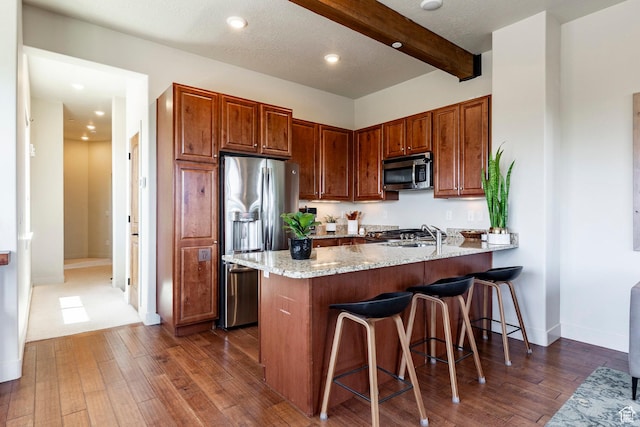 6169 Park Ln S Unit 36, Park City, UT 84098 - kitchen with appliances with stainless steel finishes, a peninsula, a breakfast bar, dark wood-style floors, and recessed lighting