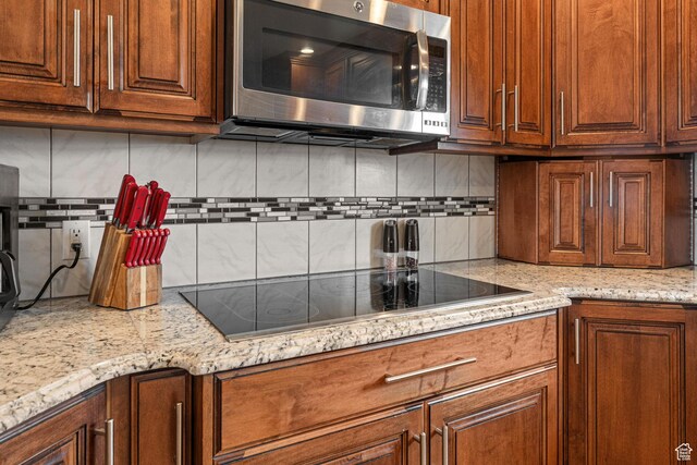 2214 S 1600 E, Preston, ID 83263 - kitchen with stainless steel microwave, black electric stovetop, decorative backsplash, and light stone countertops