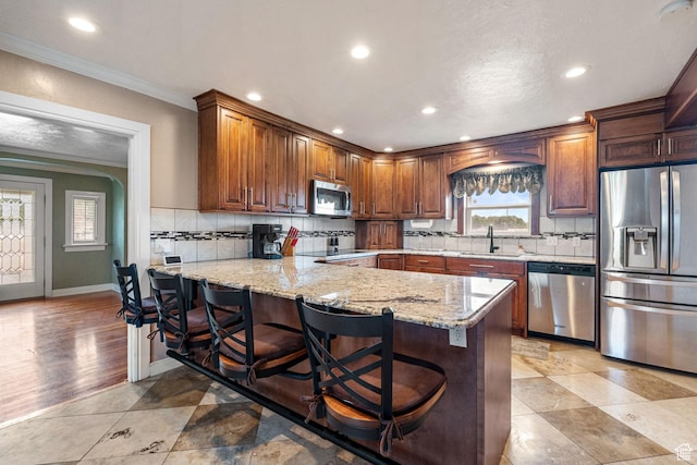 2214 S 1600 E, Preston, ID 83263 - kitchen with appliances with stainless steel finishes, crown molding, a peninsula, tasteful backsplash, and light stone countertops