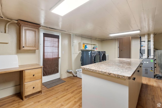 2214 S 1600 E, Preston, ID 83263 - kitchen featuring independent washer and dryer, light countertops, light wood finished floors, a kitchen island, and heating unit