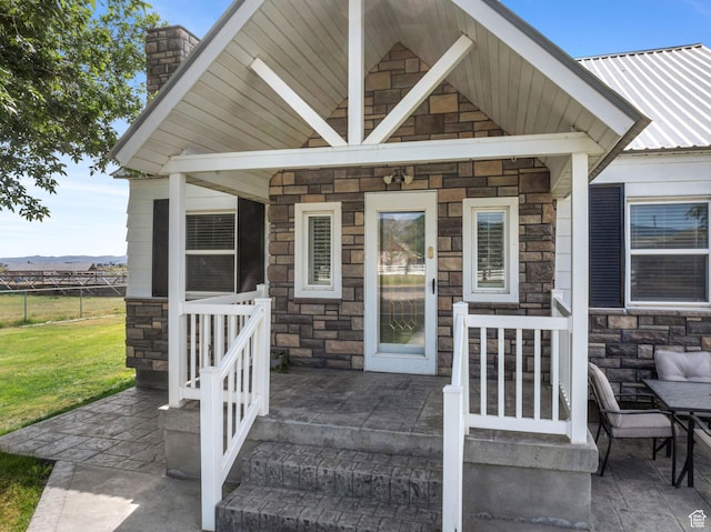 2214 S 1600 E, Preston, ID 83263 - doorway to property with stone siding, a chimney, a metal roof, and a mountain view