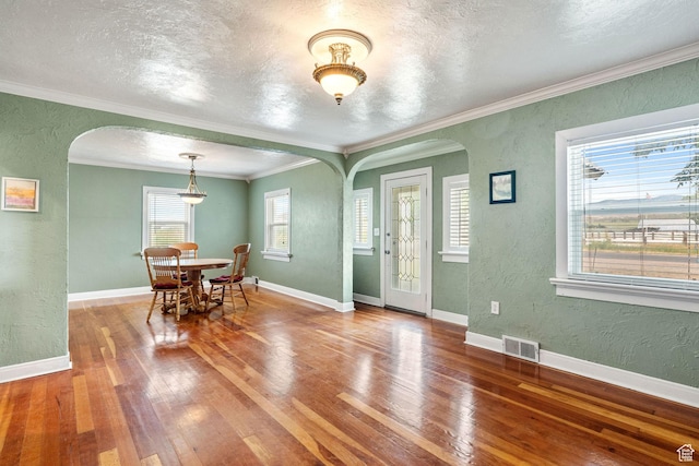 2214 S 1600 E, Preston, ID 83263 - dining room with a textured wall, arched walkways, hardwood / wood-style floors, a textured ceiling, and crown molding