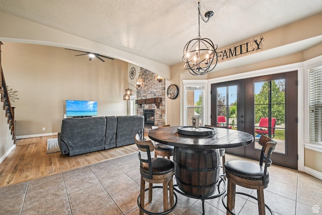 3195 N 1350 W, Pleasant View, UT 84414 - dining room with a fireplace, a textured ceiling, a chandelier, french doors, and light tile patterned floors