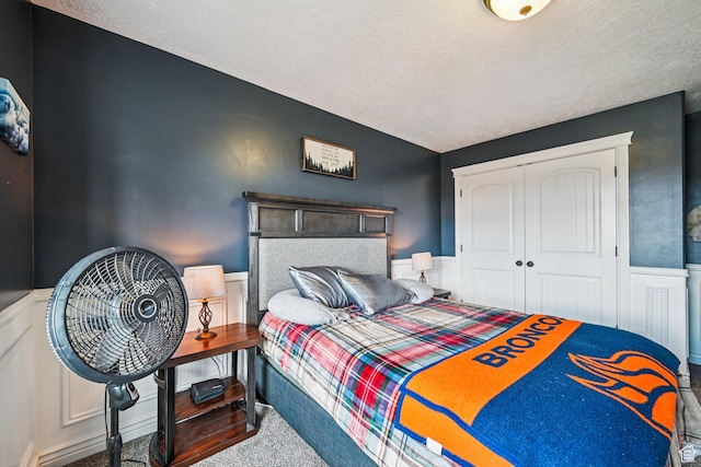 3195 N 1350 W, Pleasant View, UT 84414 - bedroom with carpet floors, a wainscoted wall, a closet, and a textured ceiling