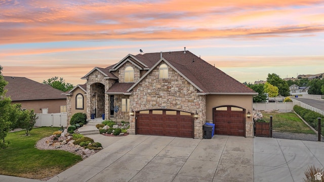 3195 N 1350 W, Pleasant View, UT 84414 - view of front of house featuring stone siding, concrete driveway, a garage, stucco siding, and a gate