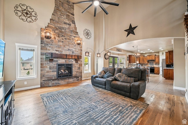 3195 N 1350 W, Pleasant View, UT 84414 - living room featuring a towering ceiling, ceiling fan, light wood-style flooring, a chandelier, and plenty of natural light
