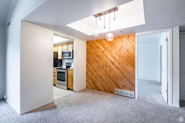 6955 N 2200 W Unit 4E, Park City, UT 84098 - kitchen with appliances with stainless steel finishes, light carpet, wood walls, an accent wall, and a skylight