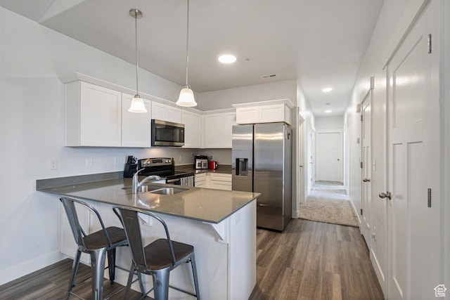 3637 W 1480 N Unit 302, Lehi, UT 84043 - kitchen featuring appliances with stainless steel finishes, dark wood-style flooring, a peninsula, white cabinetry, and a breakfast bar area