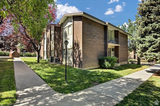 1917 S Main St Unit 7A, Bountiful, UT 84010 - view of side of property with brick siding, a lawn, and a balcony