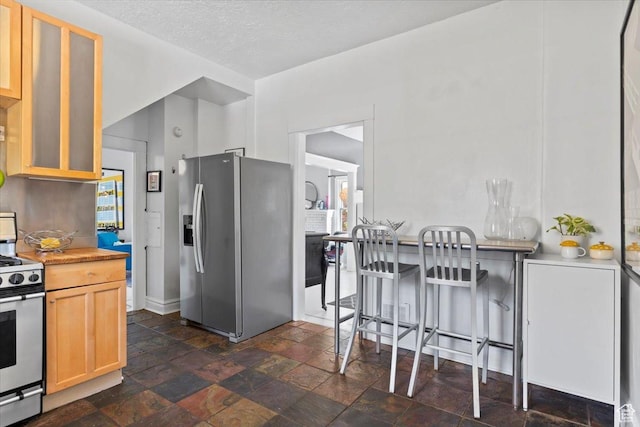368 S 1100 E, Salt Lake City, UT 84102 - kitchen with stainless steel fridge, electric stove, light brown cabinetry, glass insert cabinets, and dark stone finish flooring