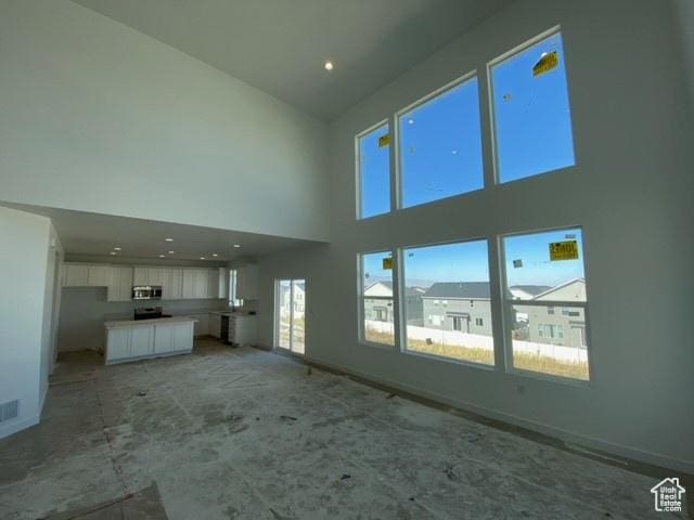 432 W Sapphire Dr Unit 7012, Tooele, UT 84074 - unfurnished living room featuring a towering ceiling and baseboards