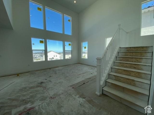 432 W Sapphire Dr Unit 7012, Tooele, UT 84074 - unfurnished living room featuring a high ceiling, plenty of natural light, and stairs