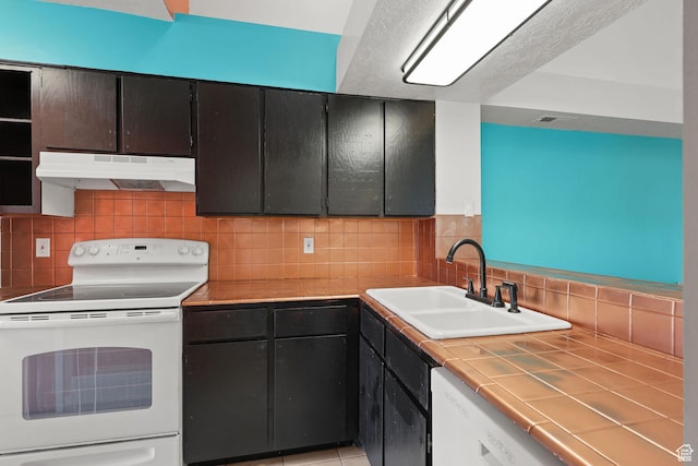 1428 W Beacon Hill Cir S Unit 1428, Salt Lake City, UT 84123 - kitchen with white appliances, under cabinet range hood, tile counters, and decorative backsplash