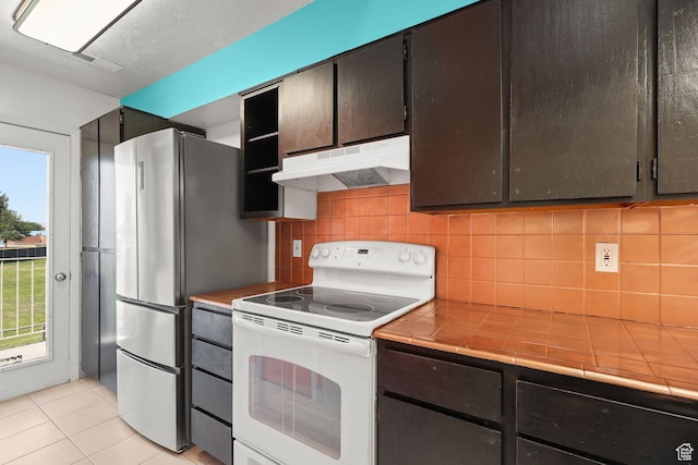 1428 W Beacon Hill Cir S Unit 1428, Salt Lake City, UT 84123 - kitchen featuring under cabinet range hood, white electric range oven, tile counters, and freestanding refrigerator