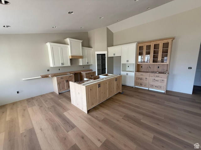 3274 N 2500 W, Farr West, UT 84404 - kitchen with wood finished floors, high vaulted ceiling, white cabinets, a center island, and glass insert cabinets