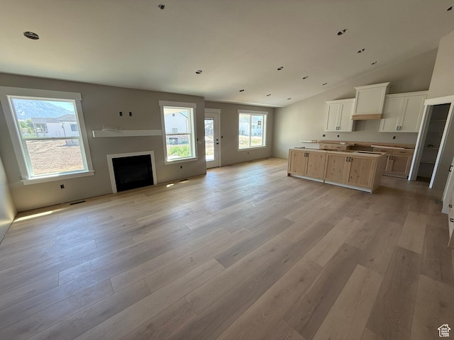 3274 N 2500 W, Farr West, UT 84404 - kitchen featuring open floor plan, light wood finished floors, a center island, vaulted ceiling, and a fireplace