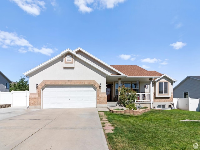 3646 S Elk Point Dr, Magna, UT 84044 - view of front of house featuring driveway, covered porch, an attached garage, a gate, and brick siding