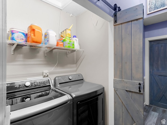 3646 S Elk Point Dr, Magna, UT 84044 - laundry room with washing machine and clothes dryer, a barn door, and wood finished floors