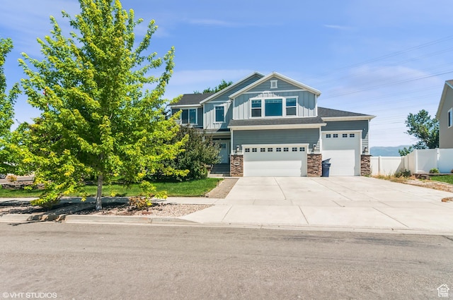 2086 W White Pine Dr S, Layton, UT 84041 - view of front facade featuring board and batten siding, stone siding, driveway, and an attached garage