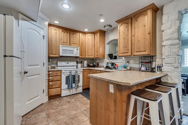 3569 E Rock Creek Rd Unit G1, Eagle Mountain, UT 84005 - kitchen featuring white appliances, a peninsula, recessed lighting, light countertops, and arched walkways