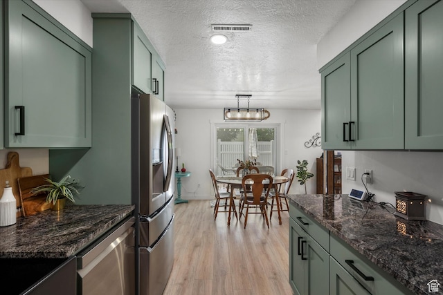 866 Brookside Ln, Centerville, UT 84014 - kitchen featuring green cabinetry, stainless steel appliances, a textured ceiling, light wood-type flooring, and dark stone counters