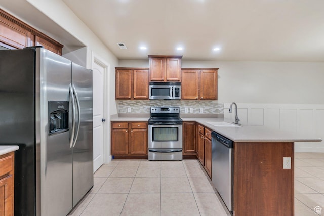 1158 W 150 S, Springville, UT 84663 - kitchen featuring stainless steel appliances, brown cabinetry, a peninsula, light tile patterned floors, and tasteful backsplash
