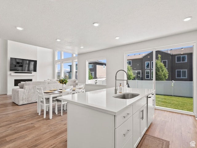 1583 W Andover Rd, South Jordan, UT 84095 - kitchen with light wood finished floors, open floor plan, light countertops, white cabinetry, and a center island with sink