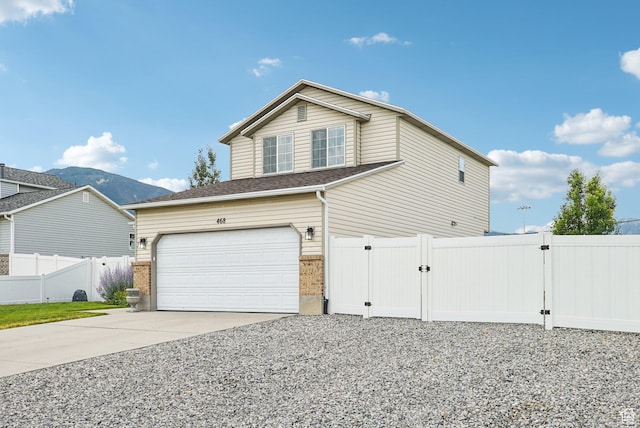 468 E Lindy Way N, Tooele, UT 84074 - view of side of property with a gate, concrete driveway, an attached garage, and brick siding