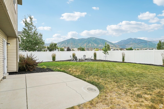 468 E Lindy Way N, Tooele, UT 84074 - fenced backyard featuring a mountain view, a patio area, and an outdoor fire pit