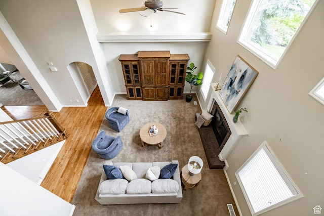 999 S Fairway Cir, Fruit Heights, UT 84037 - living room featuring a high ceiling, ceiling fan, a glass covered fireplace, wood finished floors, and arched walkways