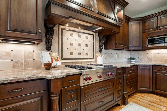 999 S Fairway Cir, Fruit Heights, UT 84037 - kitchen with appliances with stainless steel finishes, backsplash, custom range hood, dark brown cabinets, and light wood-style flooring