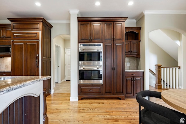 999 S Fairway Cir, Fruit Heights, UT 84037 - kitchen featuring appliances with stainless steel finishes, arched walkways, tasteful backsplash, ornamental molding, and light wood-style flooring