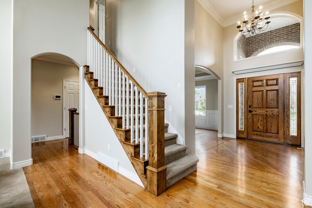 999 S Fairway Cir, Fruit Heights, UT 84037 - entryway with arched walkways, a high ceiling, a chandelier, light wood-style floors, and stairway