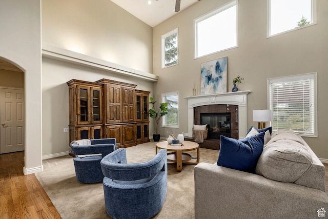 999 S Fairway Cir, Fruit Heights, UT 84037 - living room featuring high vaulted ceiling, arched walkways, light wood-style floors, a premium fireplace, and a ceiling fan