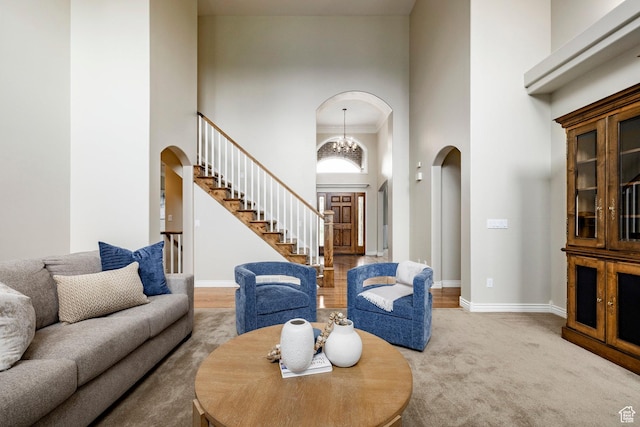 999 S Fairway Cir, Fruit Heights, UT 84037 - carpeted living area featuring arched walkways, a towering ceiling, stairway, and a chandelier