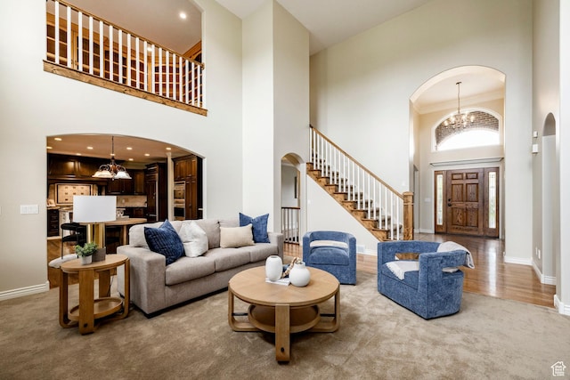 999 S Fairway Cir, Fruit Heights, UT 84037 - living area with a chandelier, a high ceiling, stairs, arched walkways, and carpet floors
