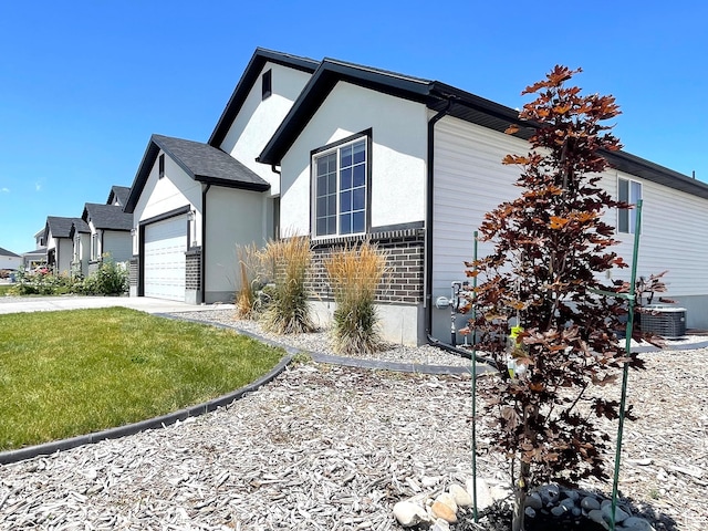 228 W 2370 N, Tooele, UT 84074 - view of home's exterior featuring a garage, driveway, stucco siding, and a lawn