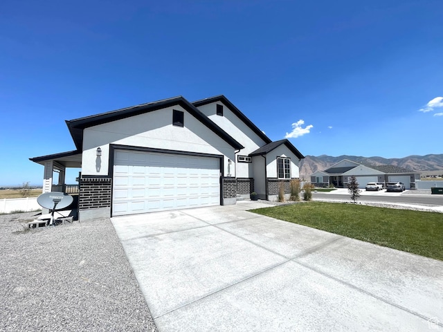 228 W 2370 N, Tooele, UT 84074 - single story home featuring an attached garage, driveway, brick siding, a mountain view, and stucco siding