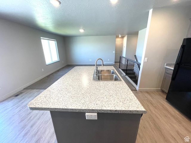 228 W 2370 N, Tooele, UT 84074 - kitchen with freestanding refrigerator, a textured ceiling, light wood-type flooring, a center island with sink, and open floor plan