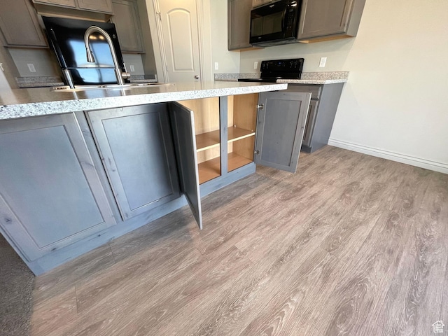 228 W 2370 N, Tooele, UT 84074 - kitchen featuring black microwave, gray cabinetry, light wood-style floors, and range
