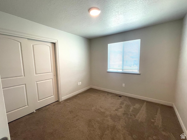 228 W 2370 N, Tooele, UT 84074 - unfurnished bedroom featuring carpet flooring, a textured ceiling, and a closet