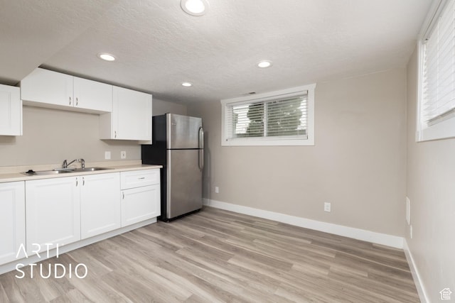 45 N 900 W, Provo, UT 84601 - kitchen featuring freestanding refrigerator, light wood-style flooring, white cabinets, light countertops, and a textured ceiling