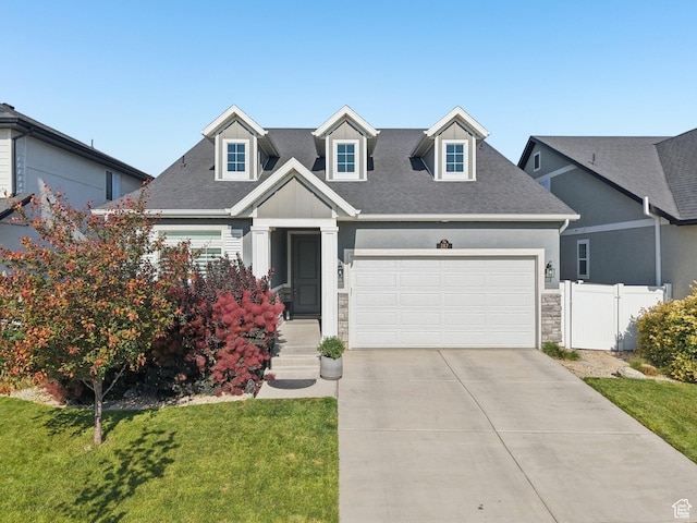 287 S Hayes Well Ln, Saratoga Springs, UT 84045 - cape cod house featuring a garage, driveway, stone siding, and roof with shingles